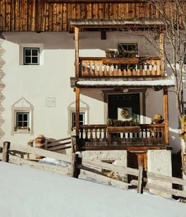 Ostí Vedl with wooden balconies, surrounded by snow.