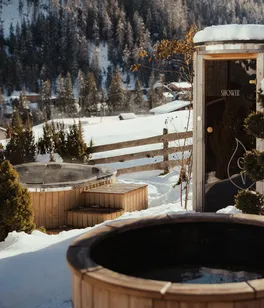 Wooden hot tubs surrounded by snow at Ostí Vedl